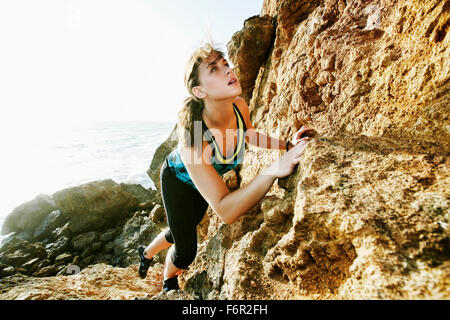 Frau auf Felsbrocken Klettern Stockfoto