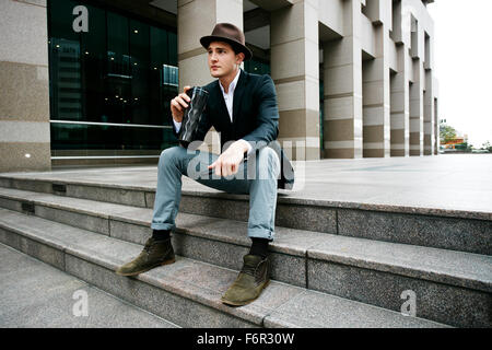 Kaukasische Geschäftsmann Kaffeetrinken auf Treppe Stockfoto