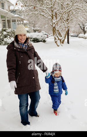 Kaukasische Mutter und Sohn wandern im Schnee Stockfoto