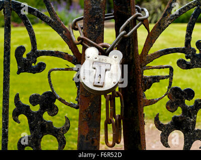 Vorhängeschloss und Metall Kette sichern ein schmiedeeisernes Tor Stockfoto