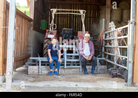 Großvater und Enkel eine Pause im Stall Stockfoto