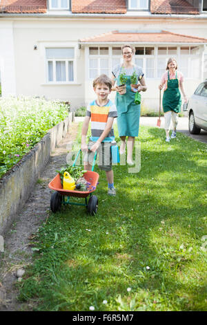 Junge drängen Schubkarre mit Pflanzen im Gemüsegarten Stockfoto