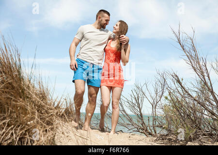 Glückliches junges Paar in Dünen wandern Stockfoto