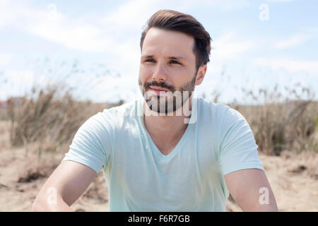 Junger Mann Tag träumen am Strand Stockfoto