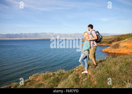 Junges Paar auf der Klippe mit Blick auf Meer Stockfoto