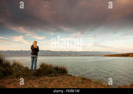 Junge Frau am Wasserrand auf dem Meer suchen Stockfoto