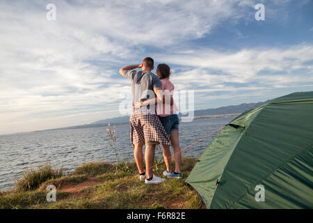 Junges Paar am Ufer mit Blick auf Meer Stockfoto