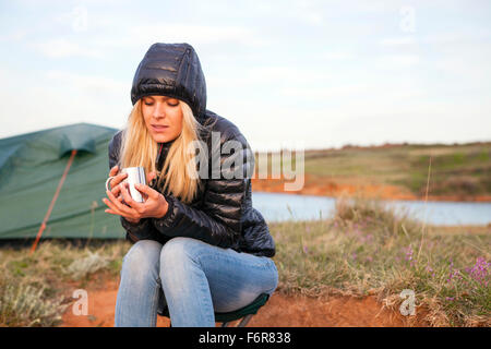 Junge Frau am Campingplatz Tasse Kaffee Stockfoto