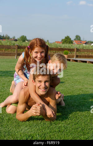 Mädchen und jungen, Kinder, Jugendliche, Geschwister im Garten, Spaß, Upper Bavaria, Bavaria, Germany Stockfoto