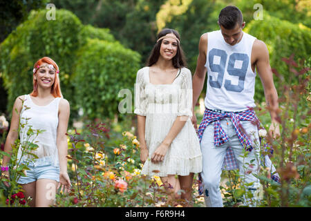 Junge Menschen im Hippie-Stil-Mode laufen im Stadtpark Stockfoto