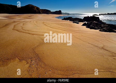 Portugal: Breiten Sandstrand mit Felsen und sanften Wellen in Porto Covo Stockfoto