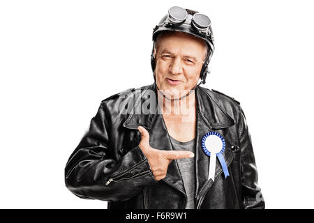 Freudige senior Biker in Richtung einer blauen Award Band auf seine schwarze Lederjacke isoliert auf weißem Hintergrund Stockfoto