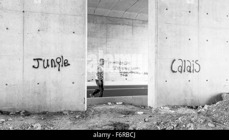 Die Dschungel-Flüchtlingslager. Ein Migrant macht seinen Weg vorbei Graffiti. Stockfoto