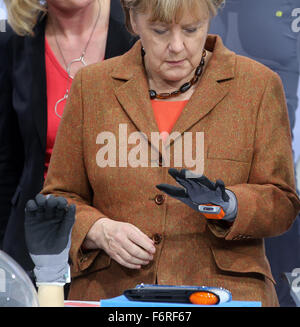 Berlin, Deutschland. 19. November 2015. Bundeskanzlerin Angela Merkel testet einen elektronischen Handschuh des 9. nationalen IT-Gipfels, Industrie 4.0 und die Digitalagenda, in Berlin, Deutschland, 19. November 2015. Foto: WOLFGANG KUMM/Dpa/Alamy Live News Stockfoto