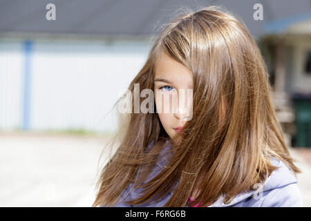 Junge Brünette lange Haare pre-adolecsent Mädchen an der Kamera, die mit einer Haltung im Freien portrait Model Release: Ja. Property Release: Nein. Stockfoto