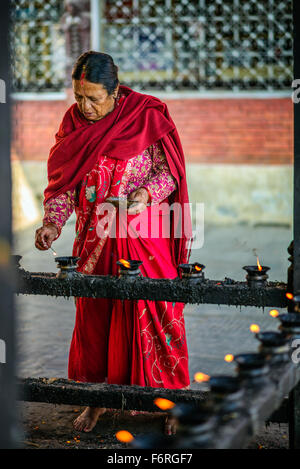 Ältere Frau Anzünden von Kerzen vor dem Gebet in einem Tempel in Kathmandu Stockfoto