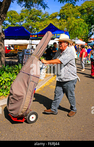 Ältere Mann schiebt seinen Kontrabass auf einem Handwagen auf dem Bauernmarkt in Santa Barbara, Kalifornien Stockfoto