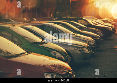 Reihen von Autos geparkt in Wohnviertel im Sonnenuntergang, Retro-getönten Bild mit Lens Flare und Bokeh Licht, selektiven Fokus Stockfoto