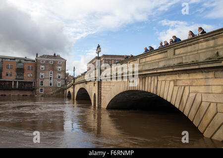 York, UK. 19. November 2015. Menschen auf der Ouse Brücke in York Blick auf die Riiver Ouse, die seine Ufer in York Stadtzentrum ist geplatzt. Bildnachweis: James Copeland/Alamy Live-Nachrichten Stockfoto