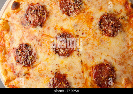 Peperoni-Pizza mit Wurst auf Holzplatte Stockfoto