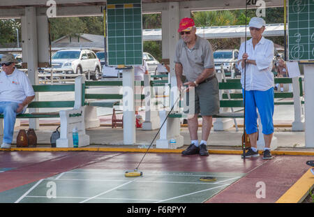 Senioren, die wettbewerbsfähige Shuffleboard Spiel in Flager Ave in New Smyrna Beach, Florida Stockfoto