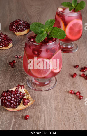 Granatapfel-cocktail mit Scheiben Limette, Minze und Eis Stockfoto