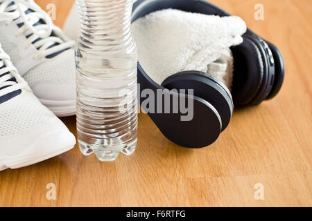 die Sport-Konzept. Kopfhörer, Schuhe und Wasser in der Flasche Stockfoto