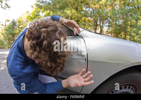 Dummer Mann bekommt in Autounfall und lächerliche Gesicht Stockfoto
