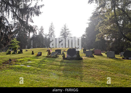 Leere Gräber auf dem Friedhof in den frühen Morgenstunden Stockfoto