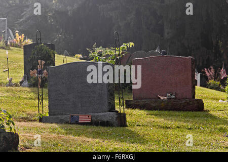 Leere Gräber auf dem Friedhof in den frühen Morgenstunden Stockfoto