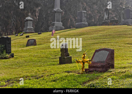 Leere Gräber auf dem Friedhof in den frühen Morgenstunden Stockfoto