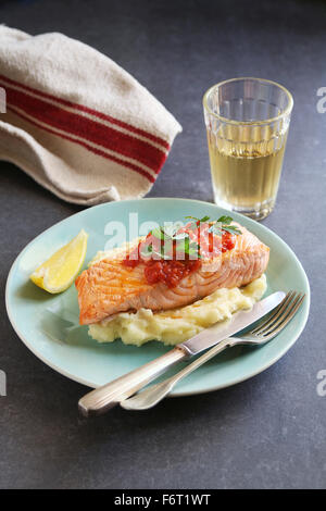 Gebratener Lachs-Steak mit gestampften Kartoffeln und Knoblauch-Tomatensauce Stockfoto