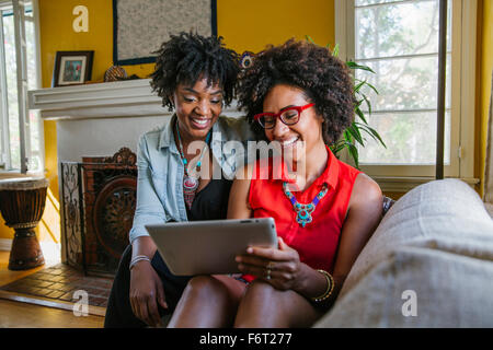 Frauen mit digital-Tablette auf sofa Stockfoto