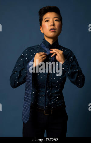 Androgyne Frau binden Krawatte Stockfoto