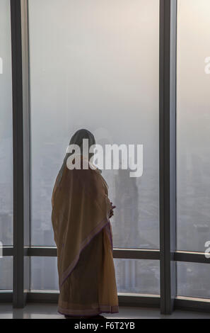 Asiatische Frau am Fenster bewundern Dubai Cityscape, Emirat Dubai, Vereinigte Arabische Emirate Stockfoto