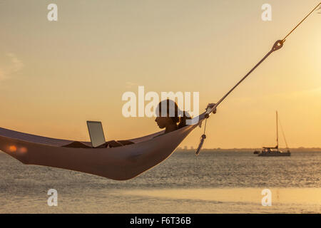 Kaukasische Frau mit Laptop in Hängematte Stockfoto