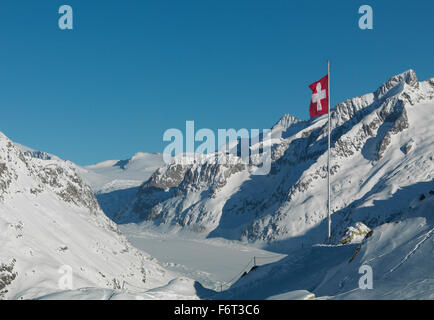 Flagge über verschneite Hänge in Bergen Stockfoto