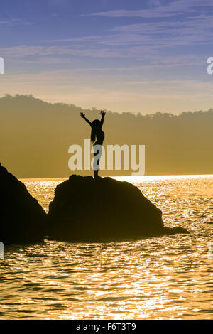 Gemischte Rassen Frau auf Felsen über dem Meer steht Stockfoto