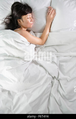 Mischrasse Frau schläft im Bett Stockfoto