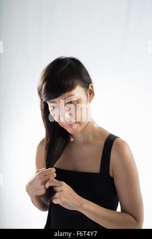Gemischte Rassen Frau verdrehen ihr Haar Stockfoto