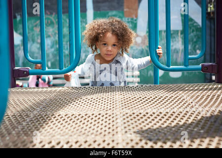 Gemischte Rassen junge Klettern auf Spielstruktur Stockfoto