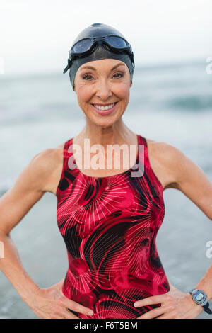 Kaukasische Schwimmer lächelnd am Strand Stockfoto