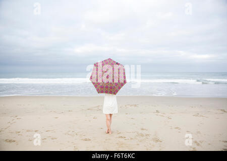 Frau mit Sonnenschirm am Strand Stockfoto