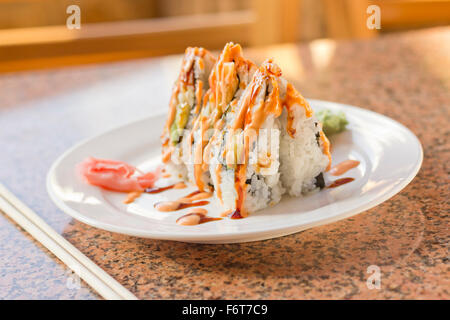 Ausgefallene California Sushi-Rolle mit Sushi Sauce und würzige Mayonnaise garniert Stockfoto