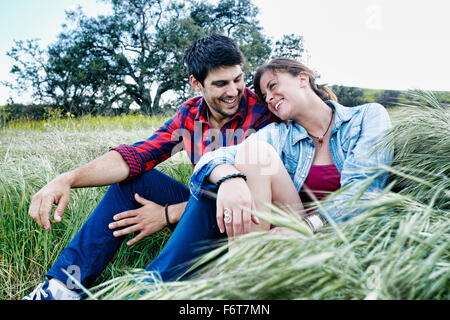 Paar sitzt im Feld Stockfoto