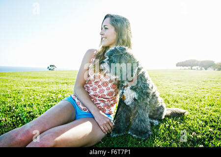 Kaukasische Frau im Feld mit Hund Stockfoto