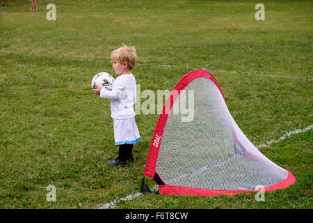 Kaukasischen Jungen spielen Fußball im Feld Stockfoto