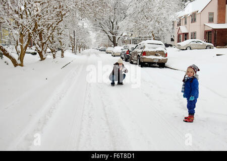 Kaukasische Mutter und Sohn spielt im Schnee Stockfoto