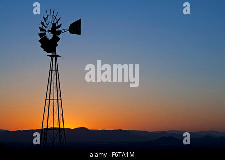 Windmühle Silhouette gegen orangefarbenen Himmel, Organ Mountains in der Nähe von Las Cruces, New Mexico, Vereinigte Staaten Stockfoto