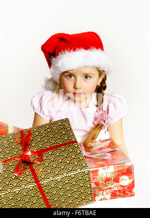 Hübsches kleines Mädchen, gekleidet in rote Nikolausmütze, Neujahr Porträt mit schönen magischen Farben Stockfoto